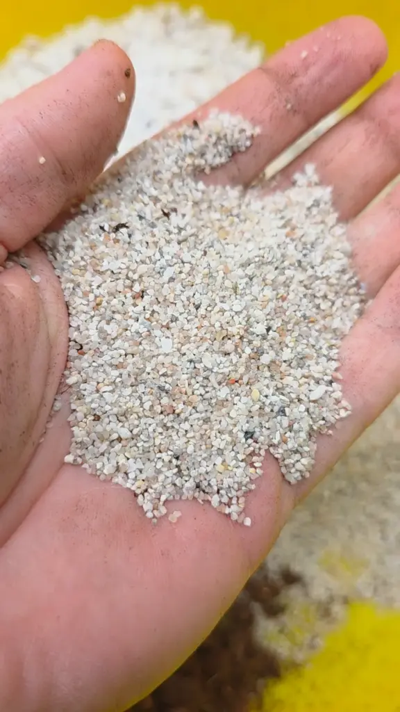 Quarzsand mit 0,7 bis 1,2 Millimeter Körnung in einer Hand